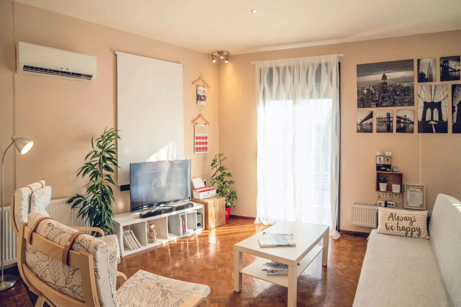 Salon meublé d'un appartement exploité en location courte durée avec télévision, climatisation et décoration cosy.